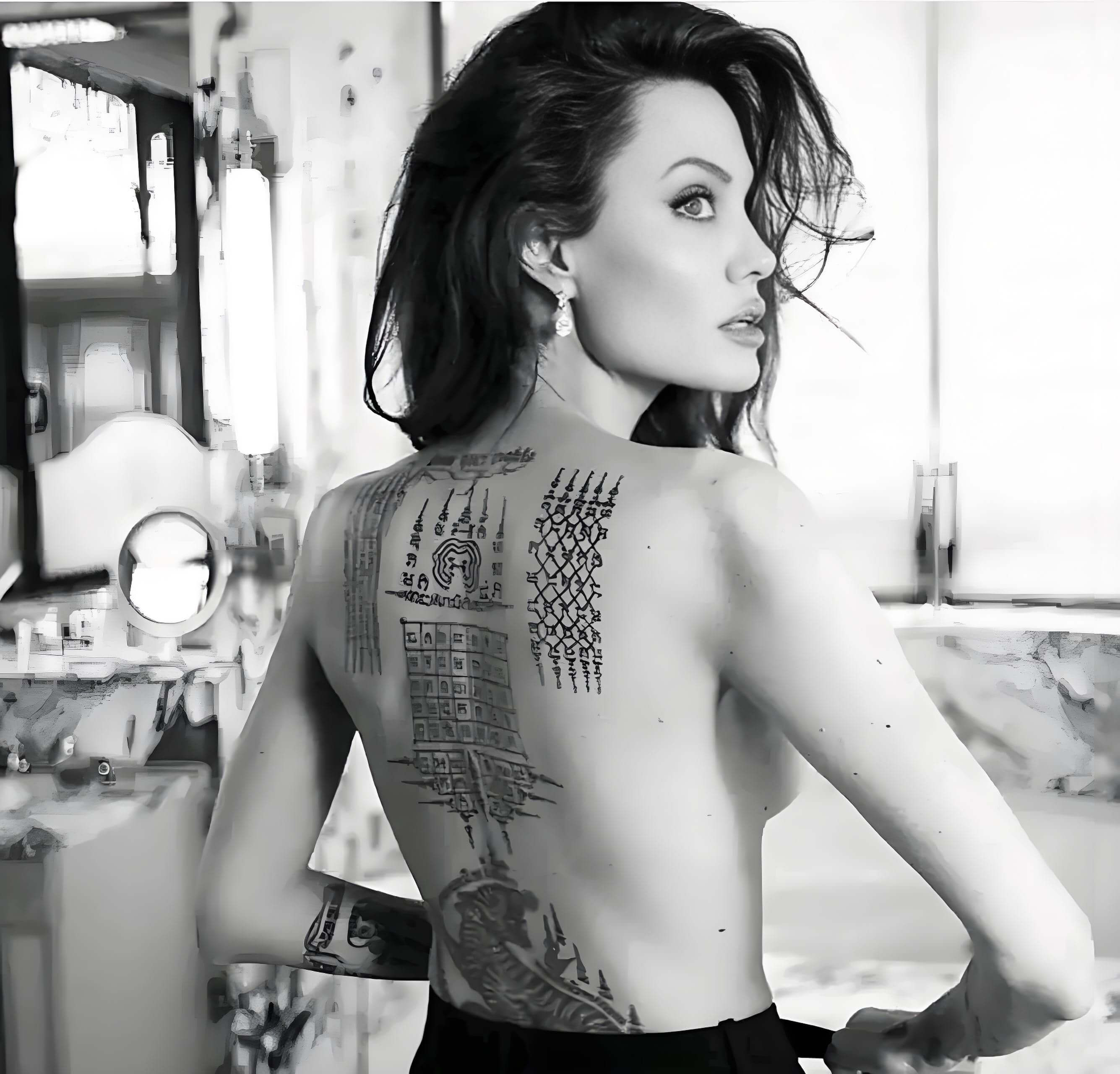 Angelina Jolie Sanskrit script and coordinates tattoos on back